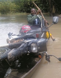 Moses Lambon. Wenn er einen Fluss überquert, um zu seinen Klienten zu gelangen, nimmt er sein Motorrad mit. Foto: OID